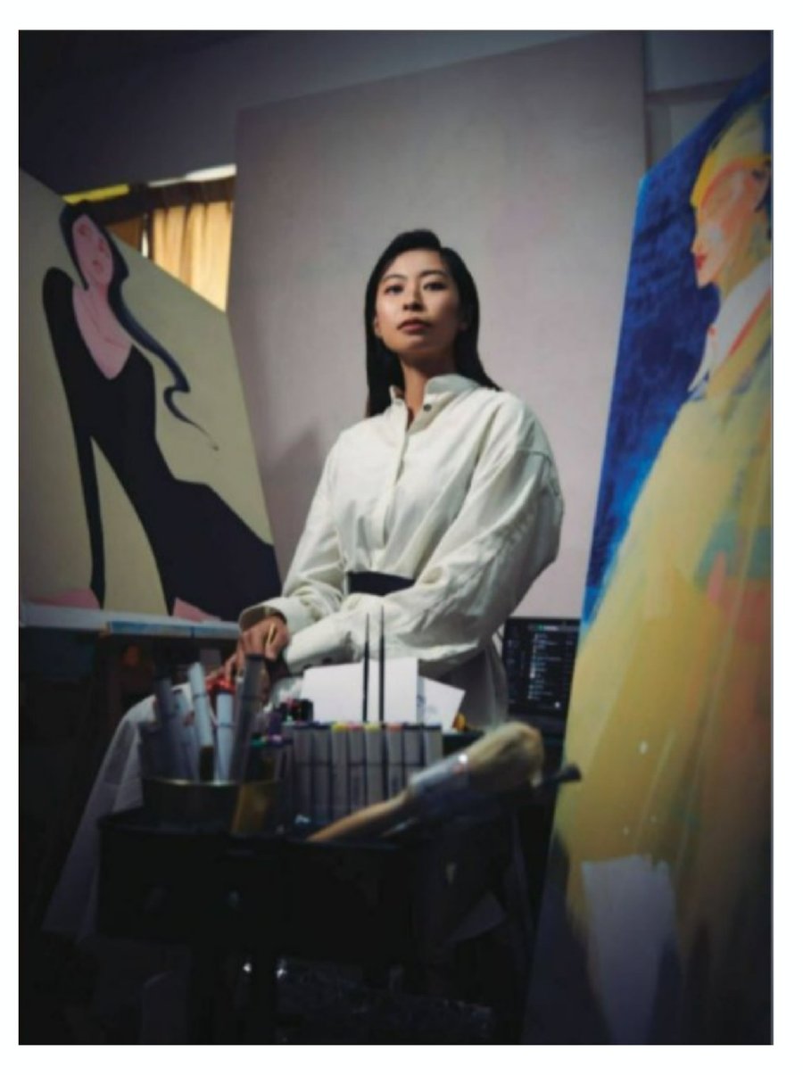 Lihuà in her studio, standing between two large watercolour paintings on easels.